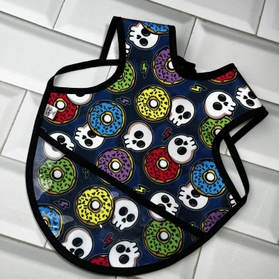 Babete para bebé com padrão de donuts e caveiras coloridos