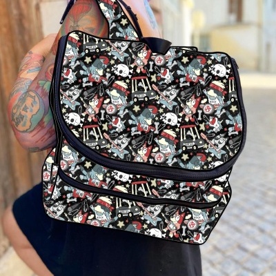 Mochila preta com padrão colorido de caveiras e símbolos, usada por pessoa com tatuagens