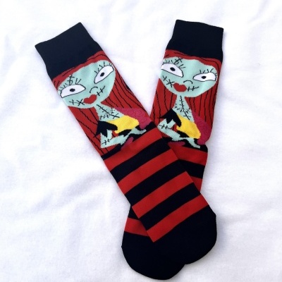 Meias com riscas pretas e vermelhas e rosto de personagem colorido