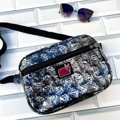 Bolsa pequena com padrão de caveiras e óculos de sol de armação prateada.