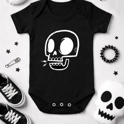 Body de bebé preto com estampado de caveira branco rodeado por ténis, pulseira preta e brinquedos de Halloween