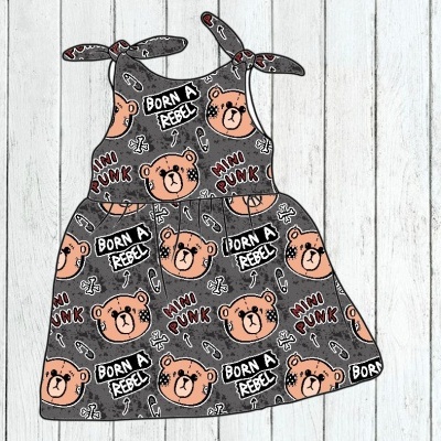 Vestido cinzento para criança com padrão de ursos e texto BORN A REBEL e MINI PUNK em fundo de madeira clara