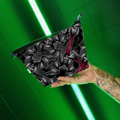Bolsa pequena triangular com padrão de morcegos pretos e cruz vermelha num fundo verde
