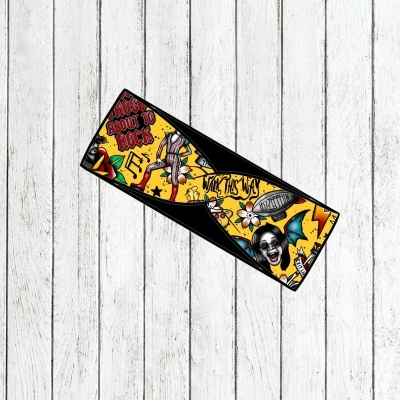 Faixa de tecido amarela com desenhos e texto em inglês colocada sobre superfície de madeira clara