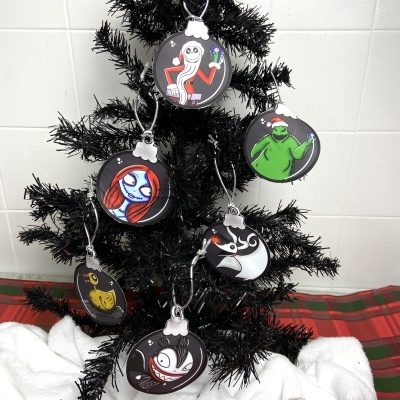 Árvore de Natal preta com bolas decorativas com personagens animados coloridos.