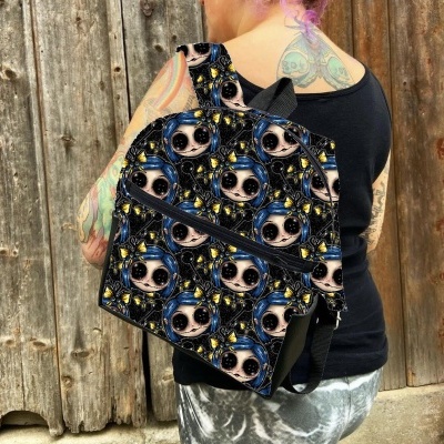 Mochila preta com padrão de caveiras coloridas usada por pessoa com tatuagens em fundo de madeira