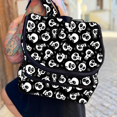 Mochila preta com padrão de caveiras brancas usada por pessoa com tatuagens no braço