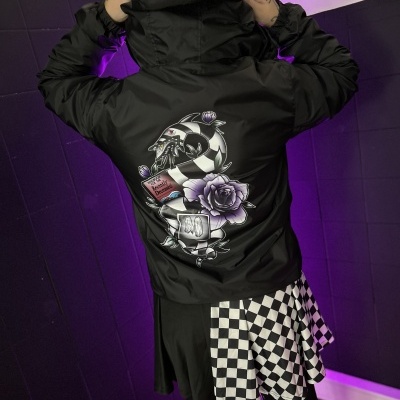 Casaco preto com estampa colorida e saia com padrão quadriculado