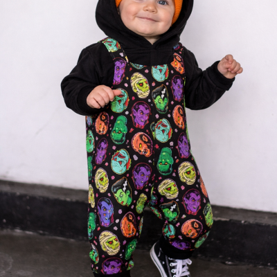 Criança vestida com roupa colorida e ténis em fundo branco.