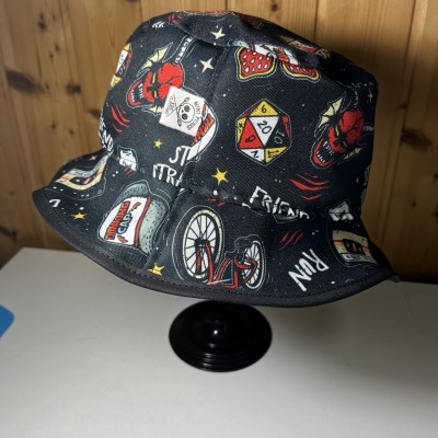 Chapéu bucket preto com várias estampas coloridas e etiqueta branca com selo de caveira