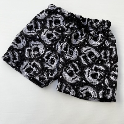 Calções pretos com padrão de caveiras brancas e cintura elástica