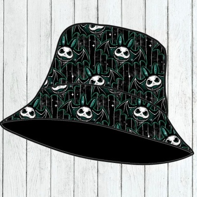 Chapéu balde preto com padrão de rostos brancos e detalhes verdes sobre madeira branca
