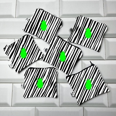 Seis pequenas bolsas de tecido listradas preto e branco com desenho verde no centro