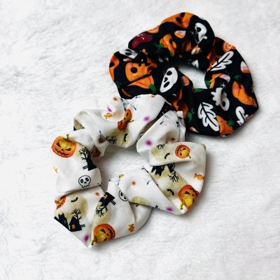 Dois scrunchies de Halloween com padrões coloridos sobre fundo branco