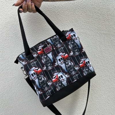 Bolsa estampada com fantasmas, lápides e morcegos, com alças pretas e etiqueta MOSHPIT MEMORIES