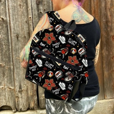 Mochila preta com padrão colorido e zíper frontal preto