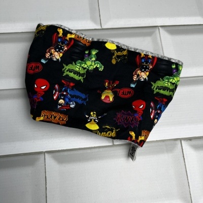 Máscara facial preta com personagens de super-heróis coloridos