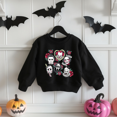 Camisola preta com personagens de terror pendurada em cabide contra parede branca decorada com morcegos e abóboras Halloween