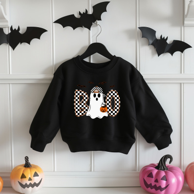 Sweatshirt preta de Halloween com estampa de fantasma e morcegos pendurada numa parede branca com decorações de morcegos e abóboras.