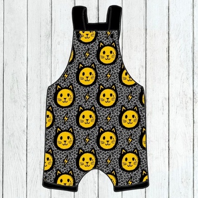 Jardineira infantil cinzenta com padrão amarelo de gatos e símbolos de relâmpagos