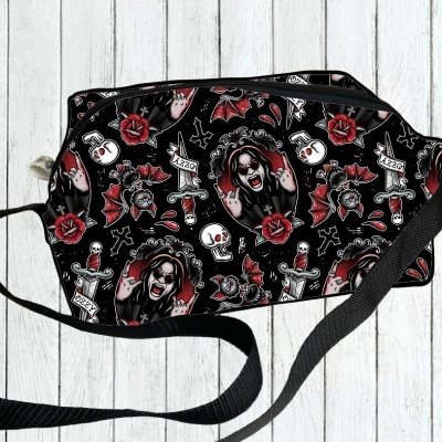 Bolsa preta com padrão de caveiras, rosas vermelhas, facas e rostos gritando