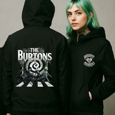 Duas pessoas com casacos pretos com estampas temáticas, fundo cinzento.