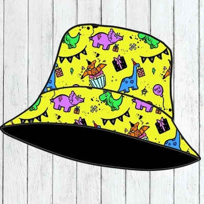 Chapéu de tecido amarelo com padrão de dinossauros coloridos e elementos festivos