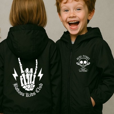 Crianças com casacos pretos com capuz e estampas brancas, uma de frente sorrindo outra de costas