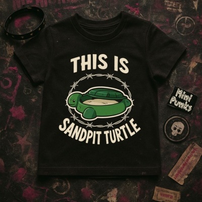 Camisola preta com estampa de tartaruga e texto, rodeada por acessórios e patches num fundo escuro