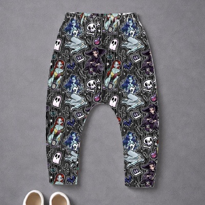 Calças de criança com padrão gótico colorido e sapatos brancos no chão cinzento