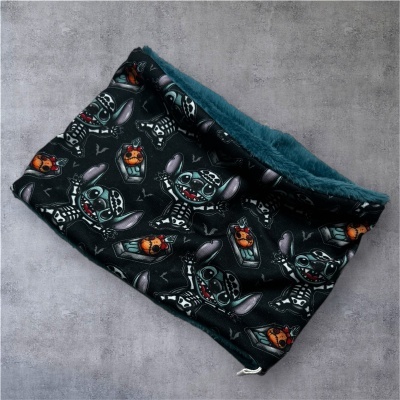 Cachecol tubular preto com padrão de criatura esqueleto e interior felpudo azul.