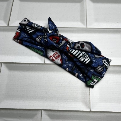 faixa de tecido preto com caveiras coloridas sobre azulejos brancos