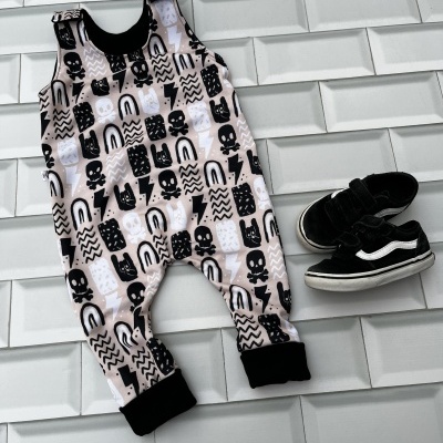 Macacão de bebé estampado e sapatilhas pretas sobre azulejos brancos 3D