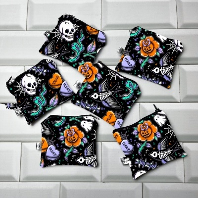 Seis saquinhos de tecido com padrão colorido místico em fundo preto sobre azulejos brancos