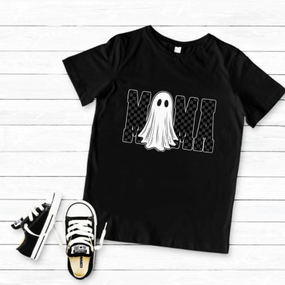 T-shirt preta com estampa de fantasma e letras M e M, com sapatilhas infantis pretas e brancas ao lado.