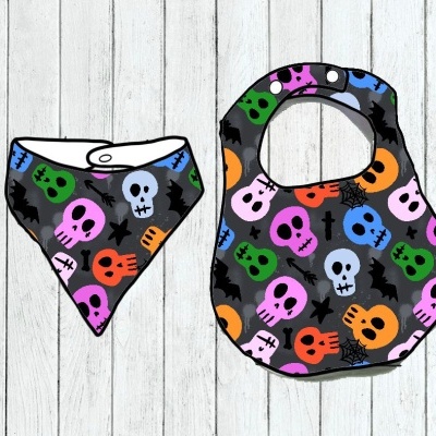 Dois babetes para bebés com padrão de caveiras coloridas e aranhas