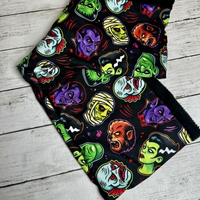 Lenço tubular com padrão colorido de monstros clássicos em fundo preto