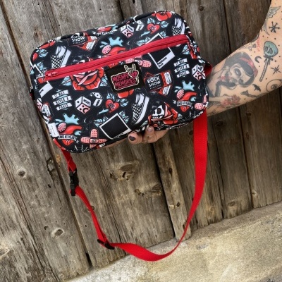 Mala tiracolo preta com padrão colorido e alça vermelha