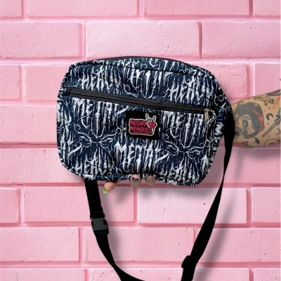 Pochete preta com padrão branco abstrato e logo MOSHPIT MEMORIES, com strap preto e fecho, em fundo de parede rosa