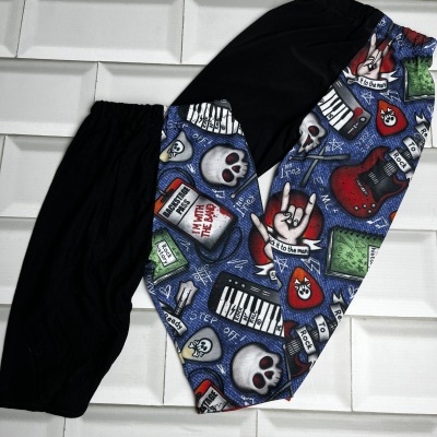 Calças compridas com padrão colorido com caveiras, guitarras, pianos e textos