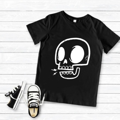 T-shirt preta com estampa de caveira branca e ténis preto e branco em chão de madeira clara