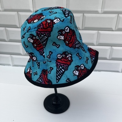 Chapéu pescador azul com padrão de gelados e ossos em suporte preto