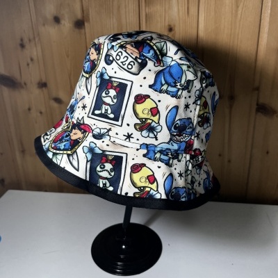 Chapéu bucket branco com estampas coloridas de personagens animados e borda preta na aba.