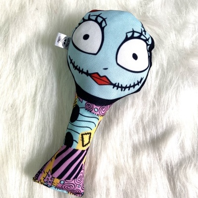 Brinquedo colorido com rosto azul sobre superfície branca peluda