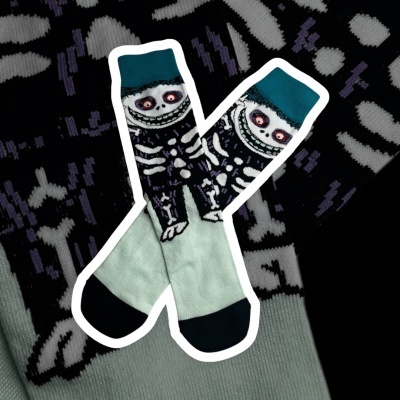Meias com padrão de esqueleto e rosto sorridente em fundo preto e branco