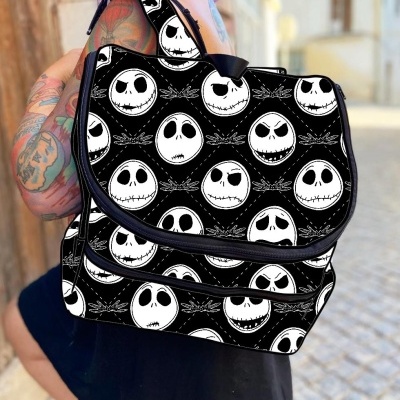 Mochila preta com padrão de caveiras brancas e expressões diferentes usada por pessoa tatuada