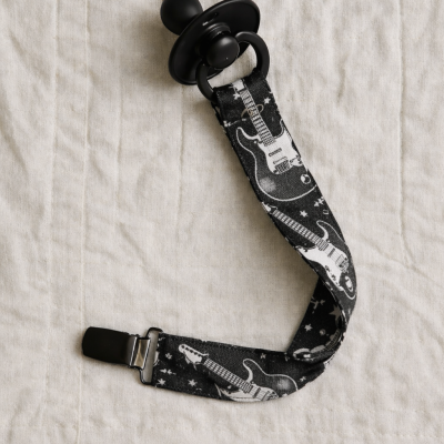 Chupeta preta com suporte de tecido preto com desenhos de guitarras eléctricas