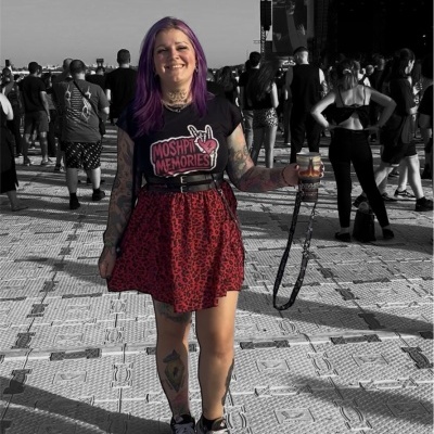 Mulher com t-shirt preta e saia vermelha num festival de música ao ar livre