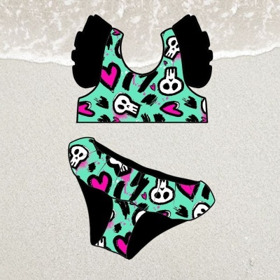 Biquíni colorido com padrão de caveiras e corações sobre areia
