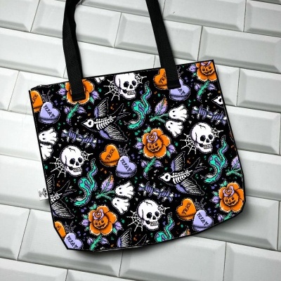 Saco de tecido com padrão colorido de caveiras, rosas, peixes esqueléticos e cobras